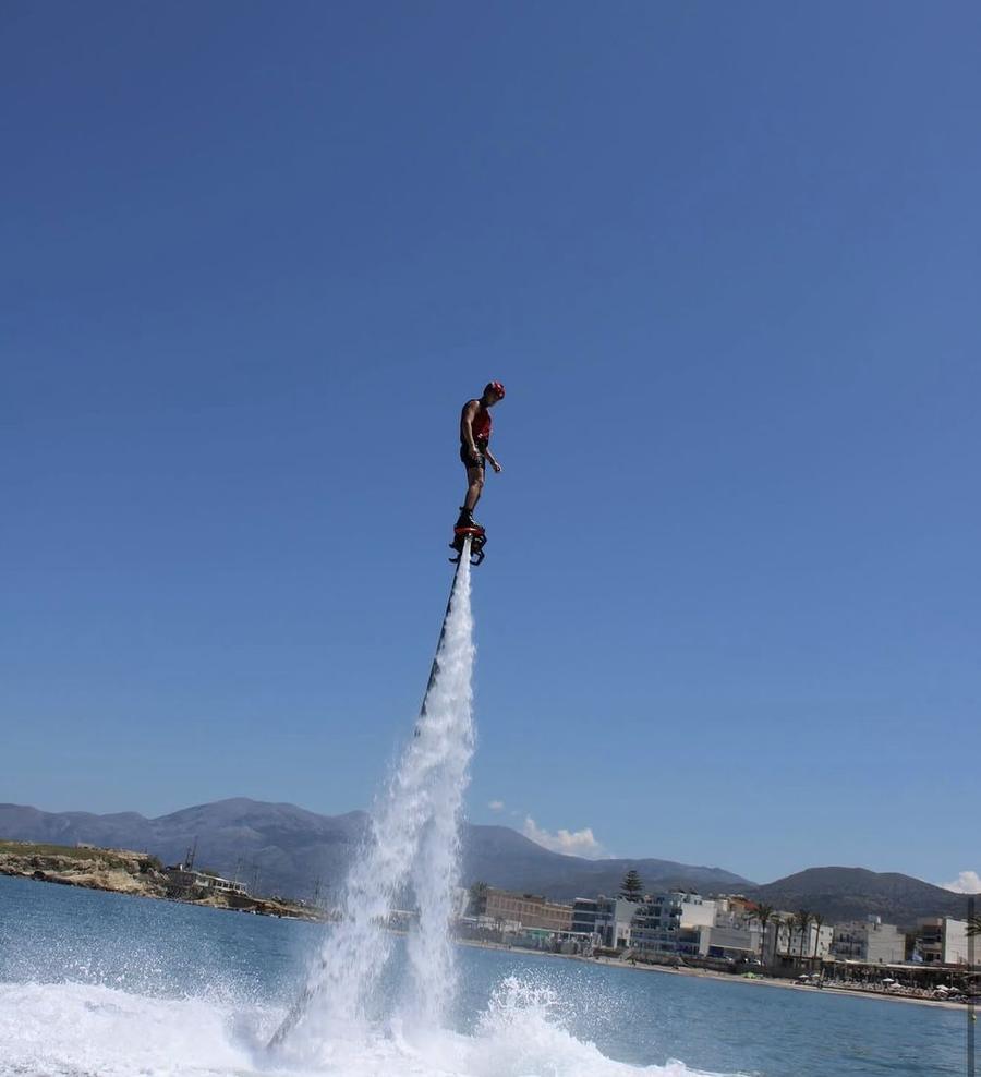 Rider high above the water on a flyboard