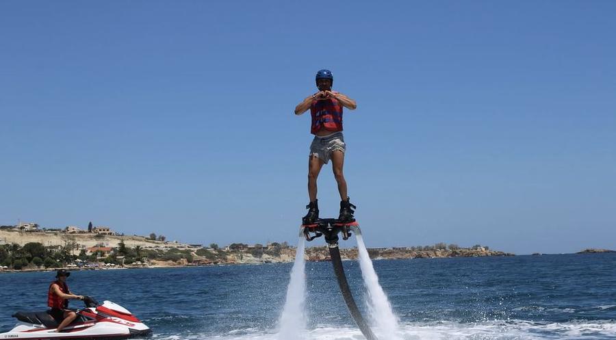 Flyboard rider with the safety jet ski alongside